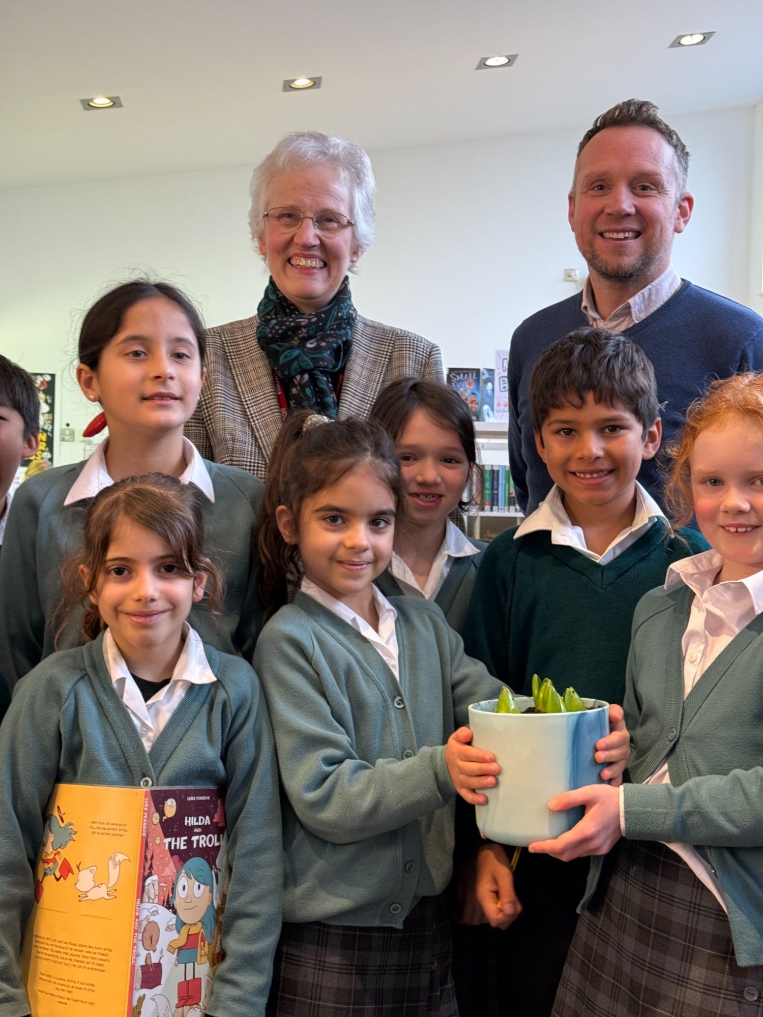 Kate Milne presenting the Junior School pupils with a birthday hyacinth